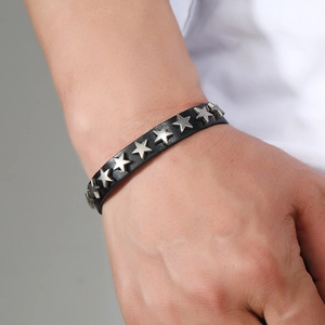 Close-up of punk leather bracelet featuring silver star studs worn on a male wrist