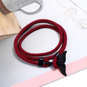 Dettaglio macro del braccialetto intrecciato rosso con chiusura a coda di balena nera