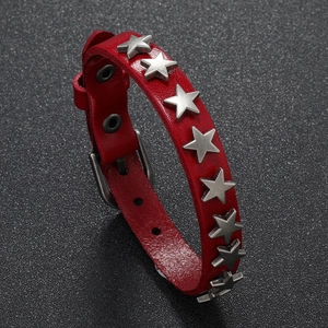 Macro shot of red leather bracelet featuring silver star studs and metal buckle closure