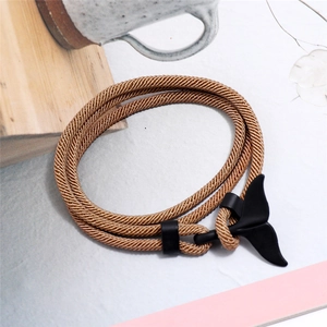 Dettaglio del bracciale in corda marrone intrecciata con chiusura a coda di balena