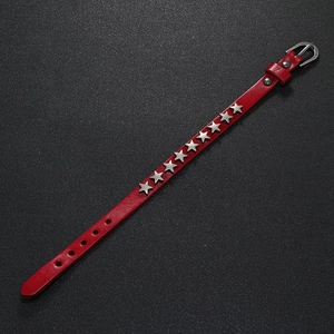 Detail view of red leather punk bracelet with silver star studs and buckle