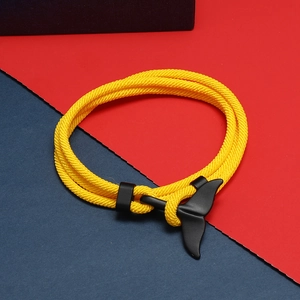 Dettaglio del bracciale corda intrecciata gialla con chiusura metallica a coda di balena