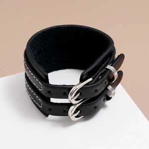 Gros plan sur bracelet en cuir PU noir avec boucles argentées et coutures blanches