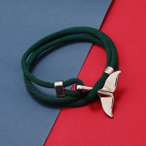 Dettaglio del bracciale in corda intrecciata verde con ciondolo a coda di balena lucida