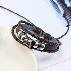 Detailed close-up of brown multi-layer braided leather bracelet with vintage silver beads
