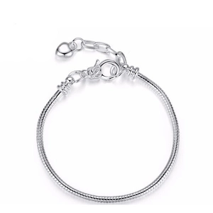 Silver snake chain bracelet with lobster clasp and heart pendant on white background