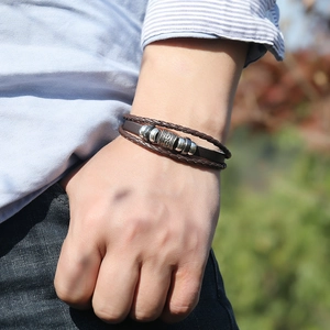 Detailed view of multilayer brown leather bracelet with ethnic metal beads on male wrist