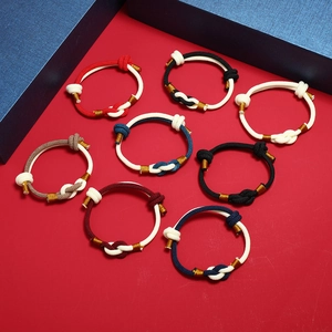Close-up of handmade braided rope bracelets with gold thread and traditional knots