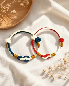 Detail of handmade red string couple bracelets with gold thread and AAA zircon