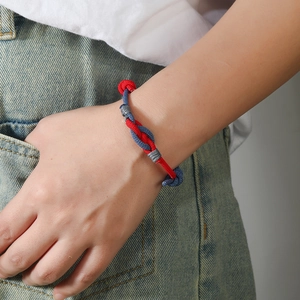Detail of red and blue braided couple bracelet showing the intricate interlocking knots