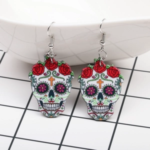 Detail of acrylic Day of the Dead sugar skull earrings with red roses and floral eyes