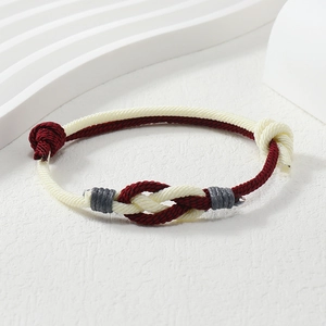 Detailed macro view of handcrafted red and beige braided rope bracelet with decorative knots