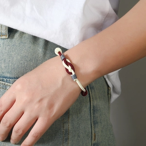 Detail of red, white, and grey braided cord bracelet with intricate knotted craftsmanship