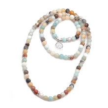Detail of multi-color stone beads necklace with silver lotus tree of life pendant