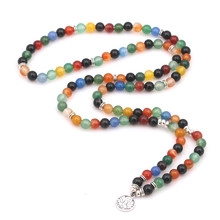 Detail of multi-color natural stone beaded long necklace with silver lotus pendant