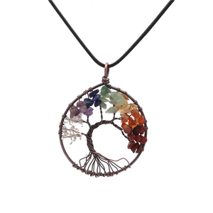 Macro view of handmade Tree of Life pendant with colorful chakra stones and copper wire