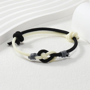 Macro detail of the dual-tone braided rope bracelet with decorative handmade knots