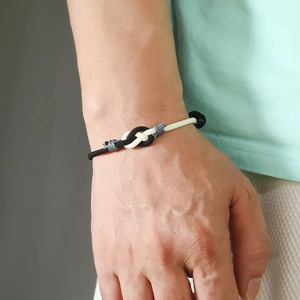 Close-up of handmade black and white braided couple bracelet with minimalist knot detail