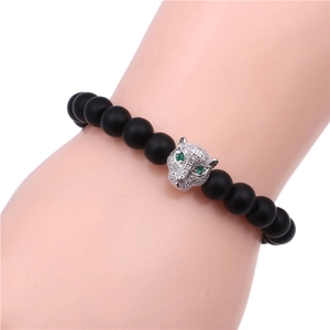 Macro detail of men's matte black bead bracelet featuring a silver zircon leopard head