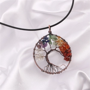Detailed macro view of handmade copper tree of life pendant with colorful chakra stones