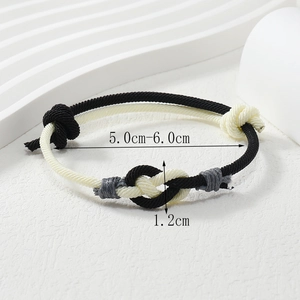 Close-up of minimalist black and white woven cord bracelet with adjustable knot design