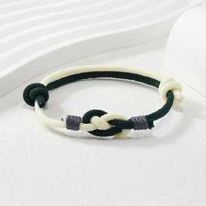 Macro detail of hand-woven green and white cord bracelet with intricate knots and texture
