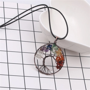 Macro shot of tree of life pendant with colorful chakra stones and copper wire