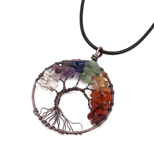 Detailed view of handmade tree of life pendant with colorful chakra healing stones