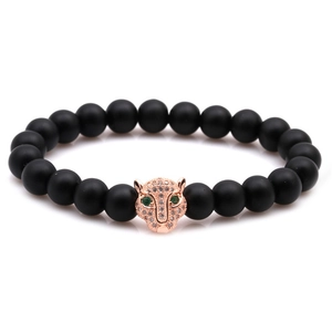Macro shot of matte black stone beads and rose gold leopard head with zircon stones