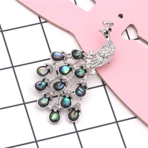 Exquise broche paon faite à la main avec incrustations de nacre et strass blancs