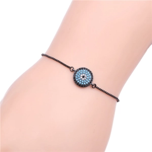 Close-up of adjustable black evil eye bracelet with blue and white zircon on a wrist