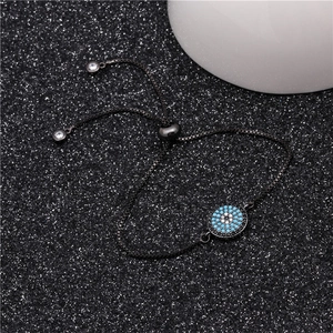 Macro detail of gunmetal adjustable Evil Eye bracelet with blue zircon and box chain