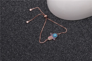 Détail du bracelet Main de Fatma en or rose avec pierres Evil Eye sur sable noir