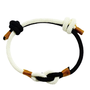 Handwoven black and white cord bracelet with bronze thread accents and nautical knots