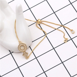 Detail of adjustable gold box chain bracelet with sparkling zircon Mars symbol pendant