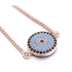 Close-up of rose gold evil eye bracelet featuring blue and white micro-pave zircons