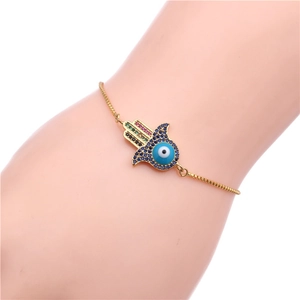 Détail d'un bracelet main de Fatma doré avec zircons colorés et œil protecteur