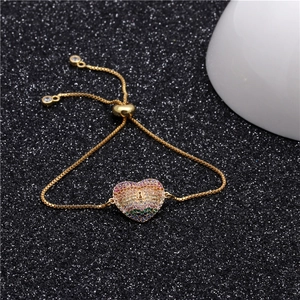 Detail of adjustable gold box chain bracelet featuring a rainbow zircon heart pendant