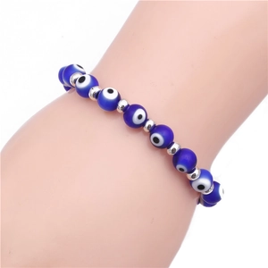 Macro shot of blue evil eye beaded bracelet with silver metal spacers on a model's wrist