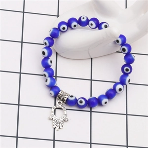 Blue Evil Eye beaded bracelet with silver Hamsa Hand charm on a display model