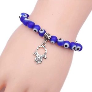 Blue Evil Eye beaded bracelet with Hamsa Hand pendant on a wrist in close-up view