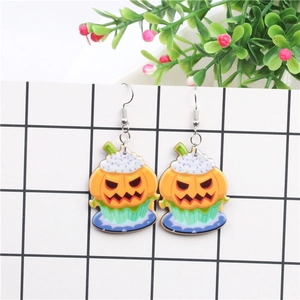 Detail of Halloween pumpkin cupcake earrings featuring orange motifs and silver hooks