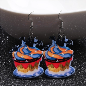 Detail of Halloween cupcake earrings with ghost and bat wings on a white bowl