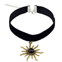 Detail of black velvet choker featuring vintage bronze charms and black gemstone pendant