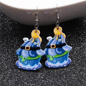 Close-up of Halloween cupcake earrings with skull and witch hat details on black background