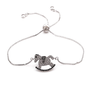 Detalle de pulsera de caballo balancín plateada con circonitas blancas y negras