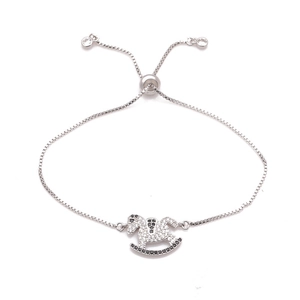 Detalle de pulsera ajustable plateada con colgante de caballo balancín y cadena de caja