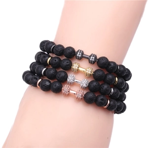 Detail of 8mm black lava stone beads and cz paved dumbbell charm on beaded bracelets