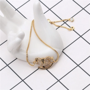 Detalle de pulsera de cadena dorada con cierre ajustable y colgante de caballo balancín pave