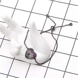 Macro detail of gunmetal heart bracelet with colorful cubic zirconia and sliding clasp